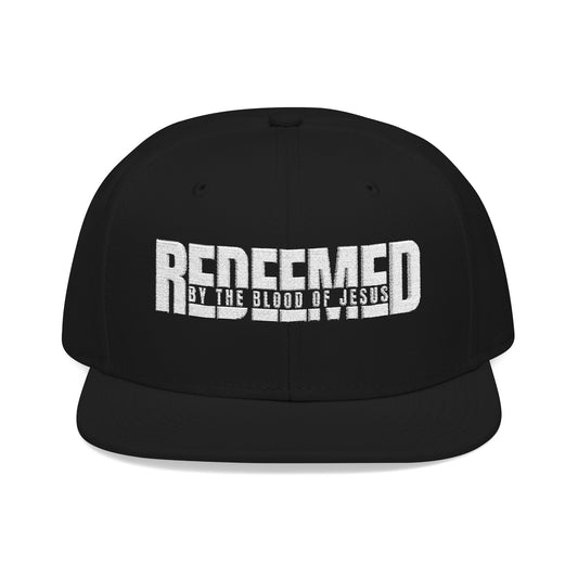 Christ Centered Faith unisex Christian snapback hat with "Redeemed By The Blood Of Jesus" text embroidered in white on black background.