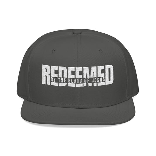 Christ Centered Faith unisex Christian snapback hat with "Redeemed By The Blood Of Jesus" text embroidered in white on charcoal gray background.
