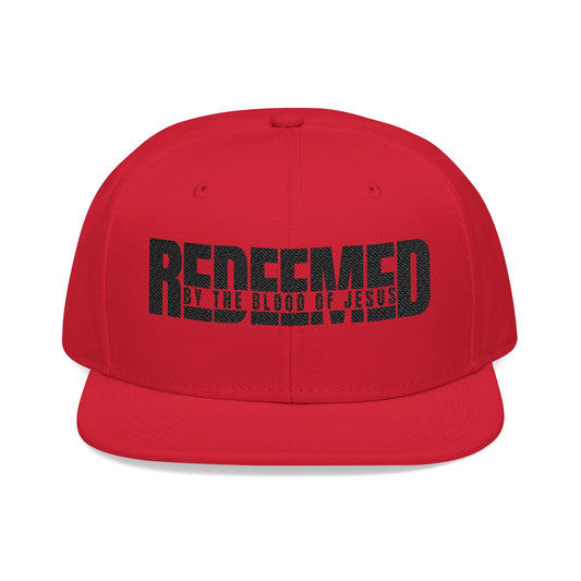Christ Centered Faith unisex Christian snapback hat with "Redeemed By The Blood Of Jesus" text embroidered in black on red background.