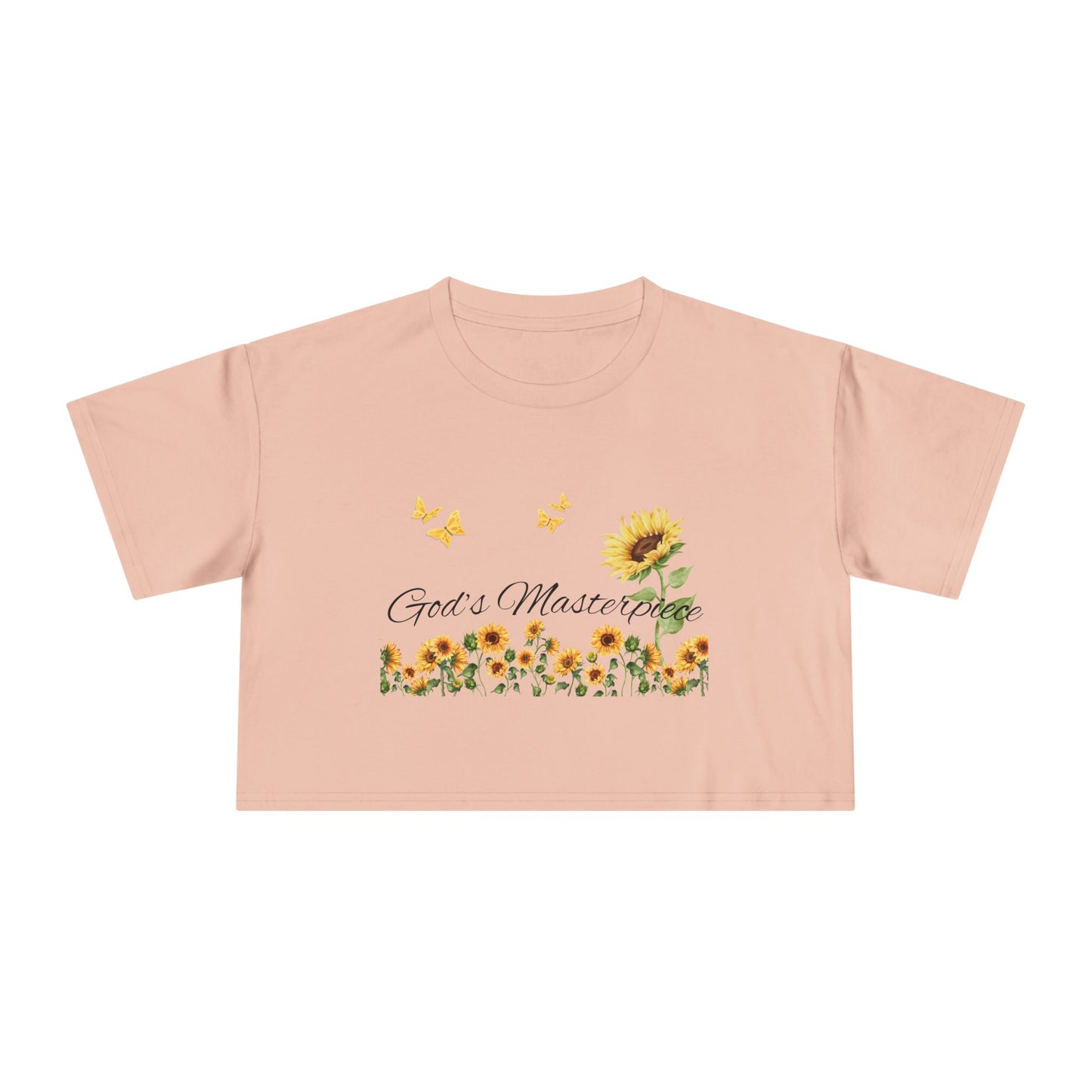 Christ Centered Faith women's cropped Christian t-shirt with "God's Masterpiece" text in black surrounded by sunflowers and yellow butterflies on pale pink background.