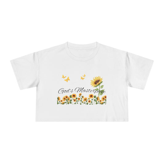 Christ Centered Faith women's cropped Christian t-shirt with "God's Masterpiece" text in black surrounded by sunflowers and yellow butterflies on white background.
