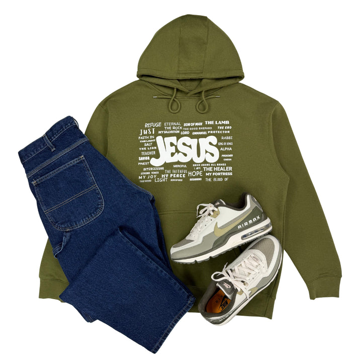 Military green Christian hoodie featuring the names of Jesus styled with blue jeans and sneakers on a white background.